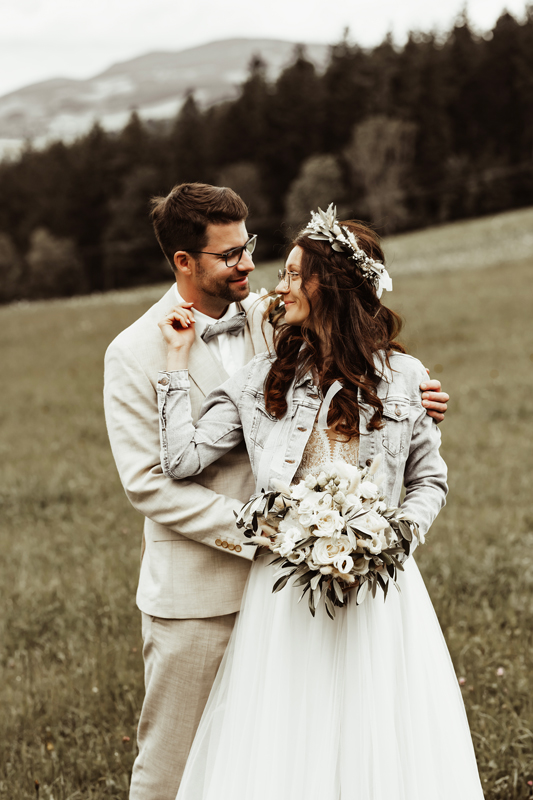 Brautpaar stehen hintereinander und schauen sich beide an.